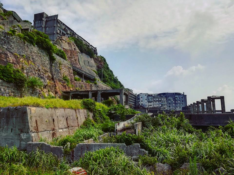 Hashima, dans un très sale état, principalement à cause des fréquents typhons ravageant la zone. Au fond, les habitations des travailleurs.